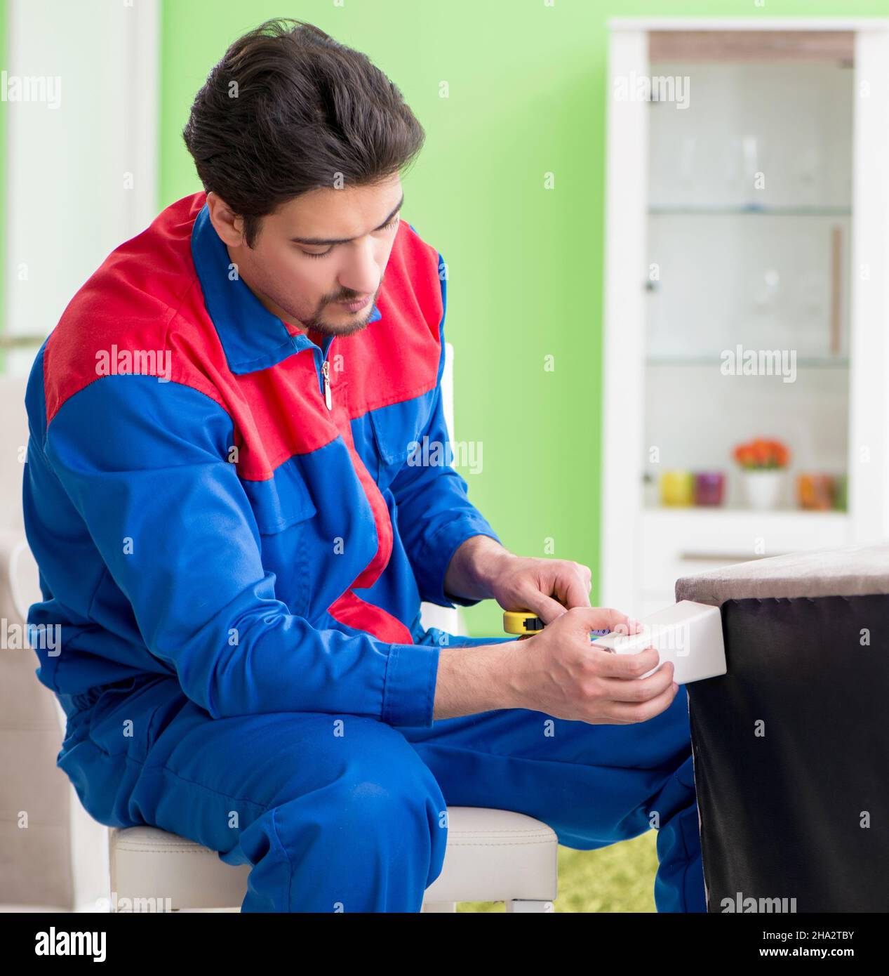 The repair contractor repairing broken furniture at home Stock Photo