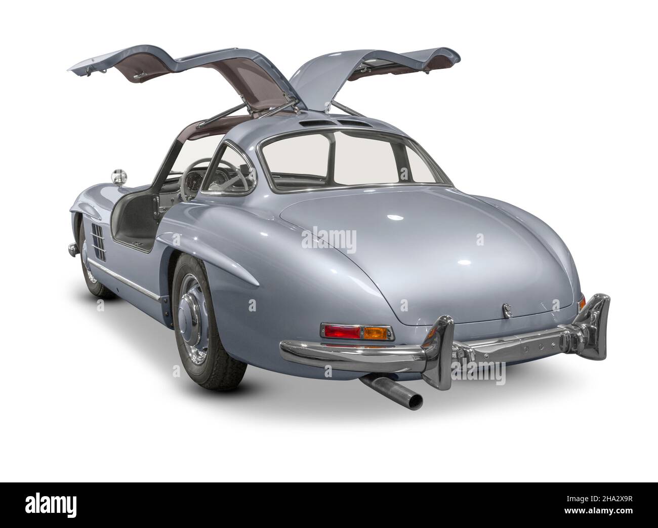 Silver colored historic vehicle with open gull-wing doors in white back Stock Photo