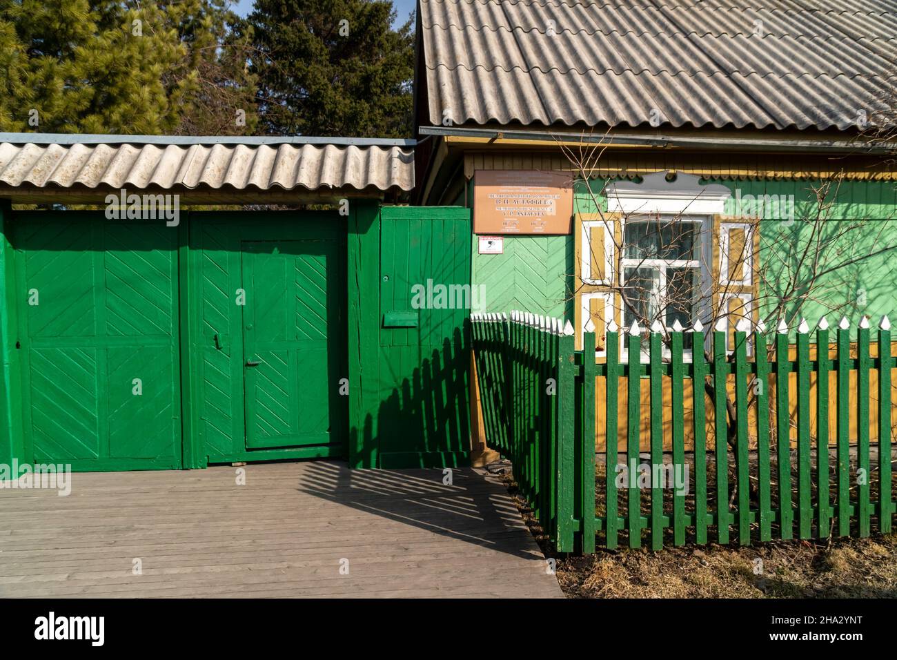 Wooden gates and a gate to the house-museum of the writer V.P. Astafiev with a memorial plaque at the entrance on a sunny spring day. Stock Photo