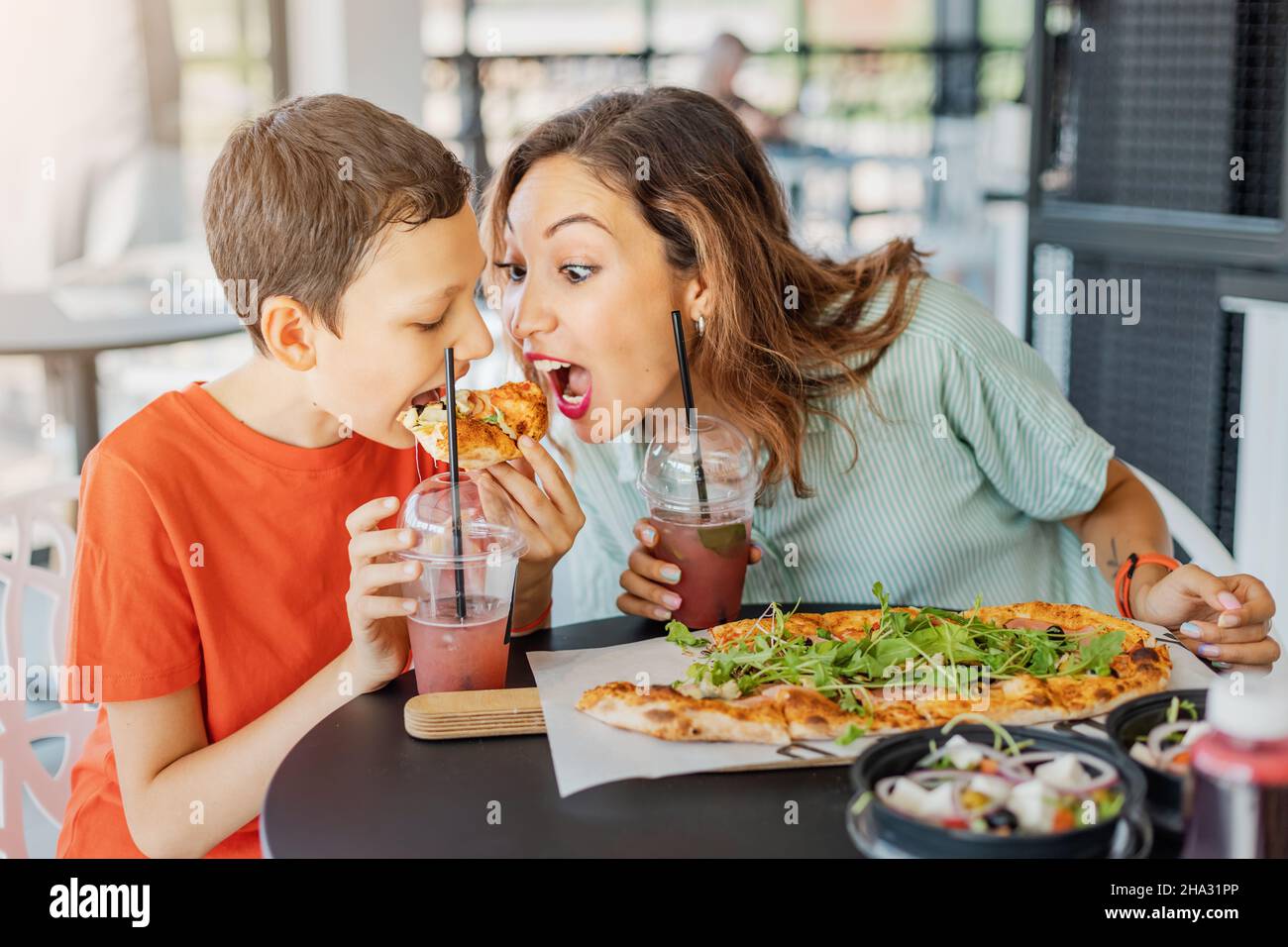 Mother and son eat delicious Italian pizza in a pizzeria or cafe. Joint  leisure and fast food concept Stock Photo - Alamy