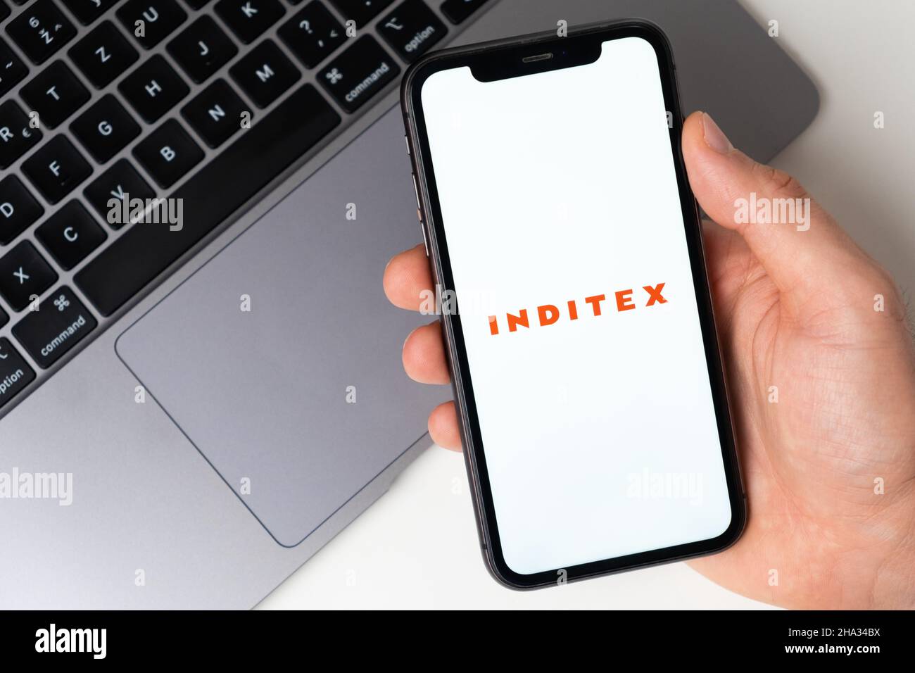 Inditex mobile application on the smartphone screen. Make purchases while sitting at home using a mobile app or laptop. A smartphone in a man hand. November 2021, San Francisco, USA Stock Photo