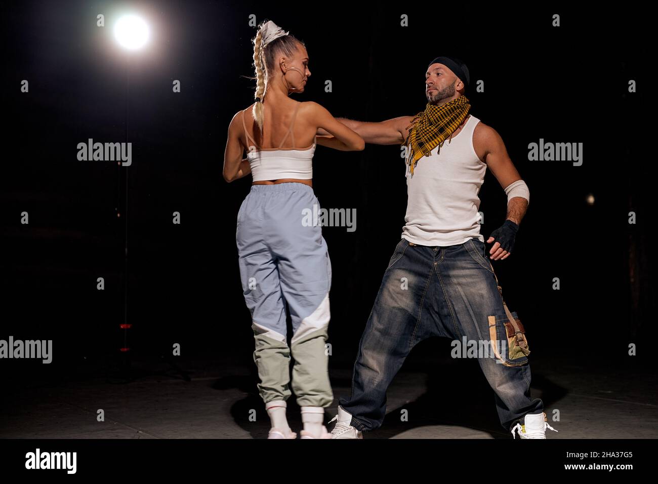 Black and caucasian couple dancing contemporary dance in studio.black