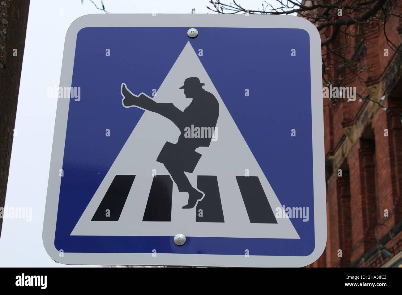 Sign showing a silhouette of a man in a bowler hat with a briefcase kicking his leg up high. (Charlottetown, PEI, Canada) Stock Photo