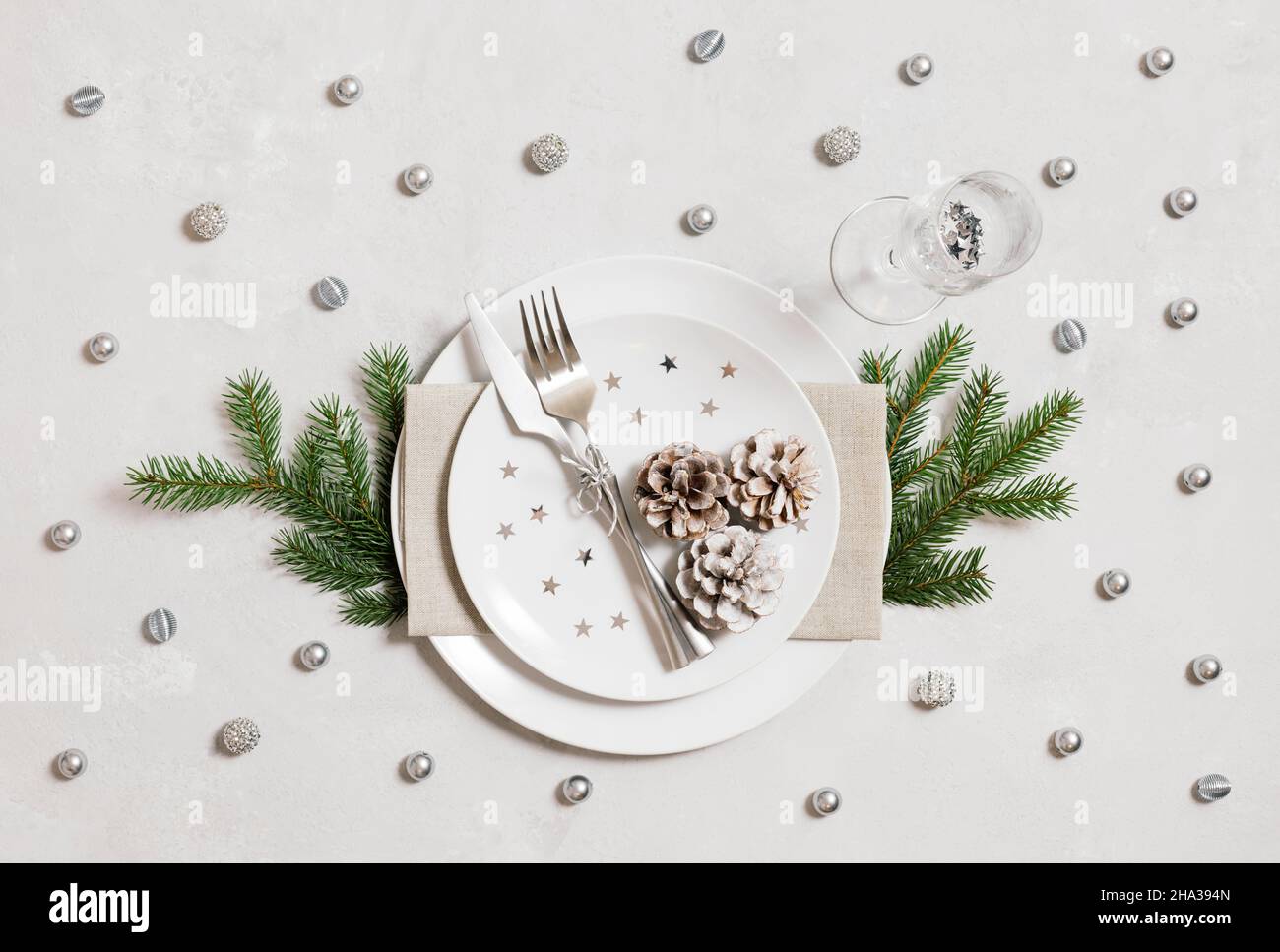 Christmas table setting with silver decorations on a gray background. Top view, flat lay. New Year party. Stock Photo