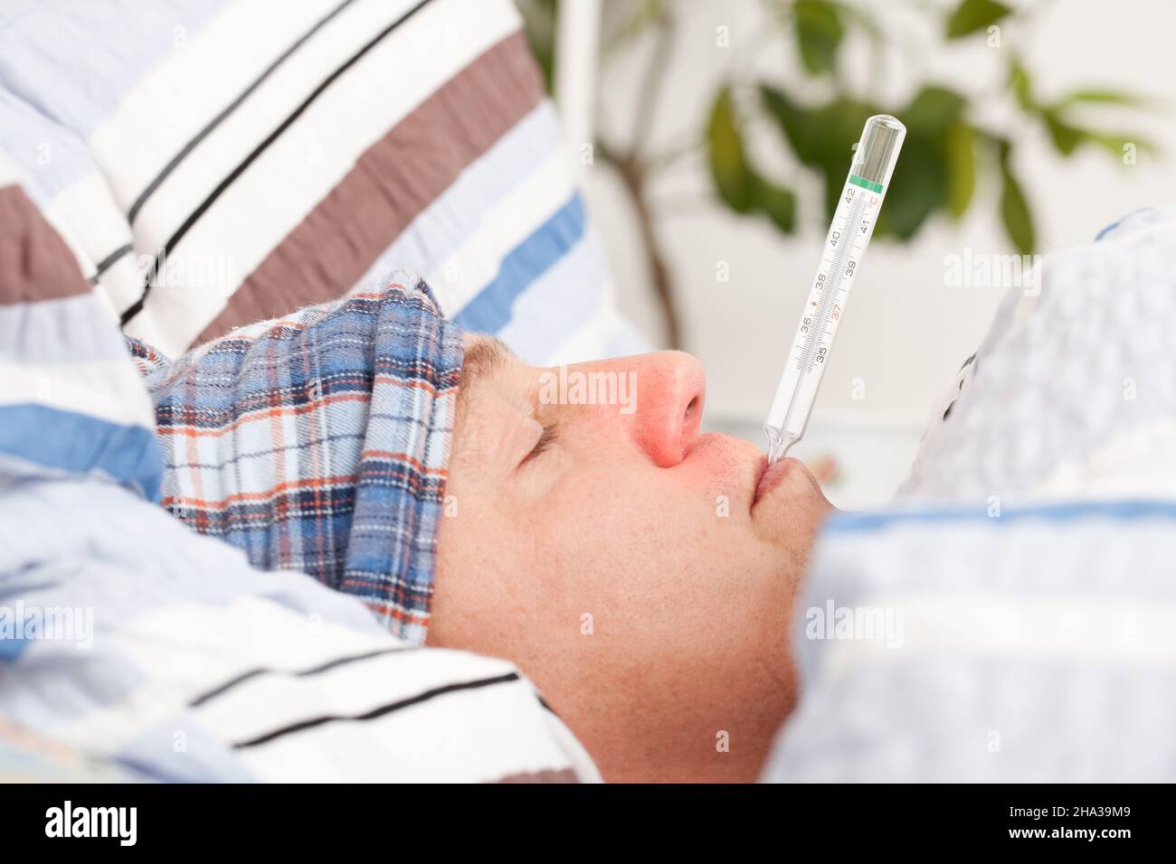 Man with clinical thermometer in his mouth sleepy, bed cover, measure, mouth, head, face, Stock Photo