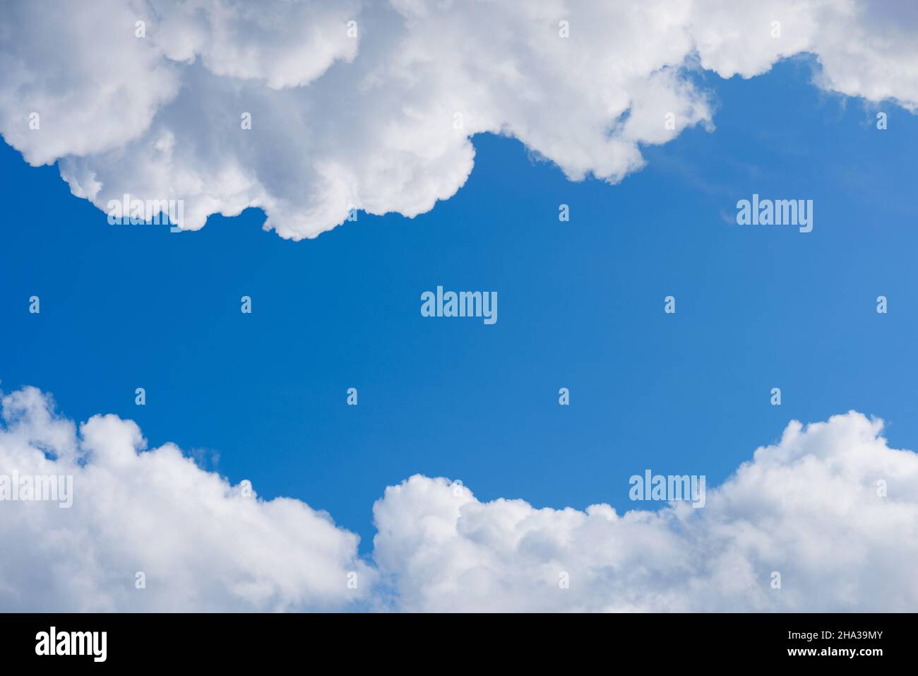 Fluffy white clouds on deep blue sky, frame with copy-space Stock Photo
