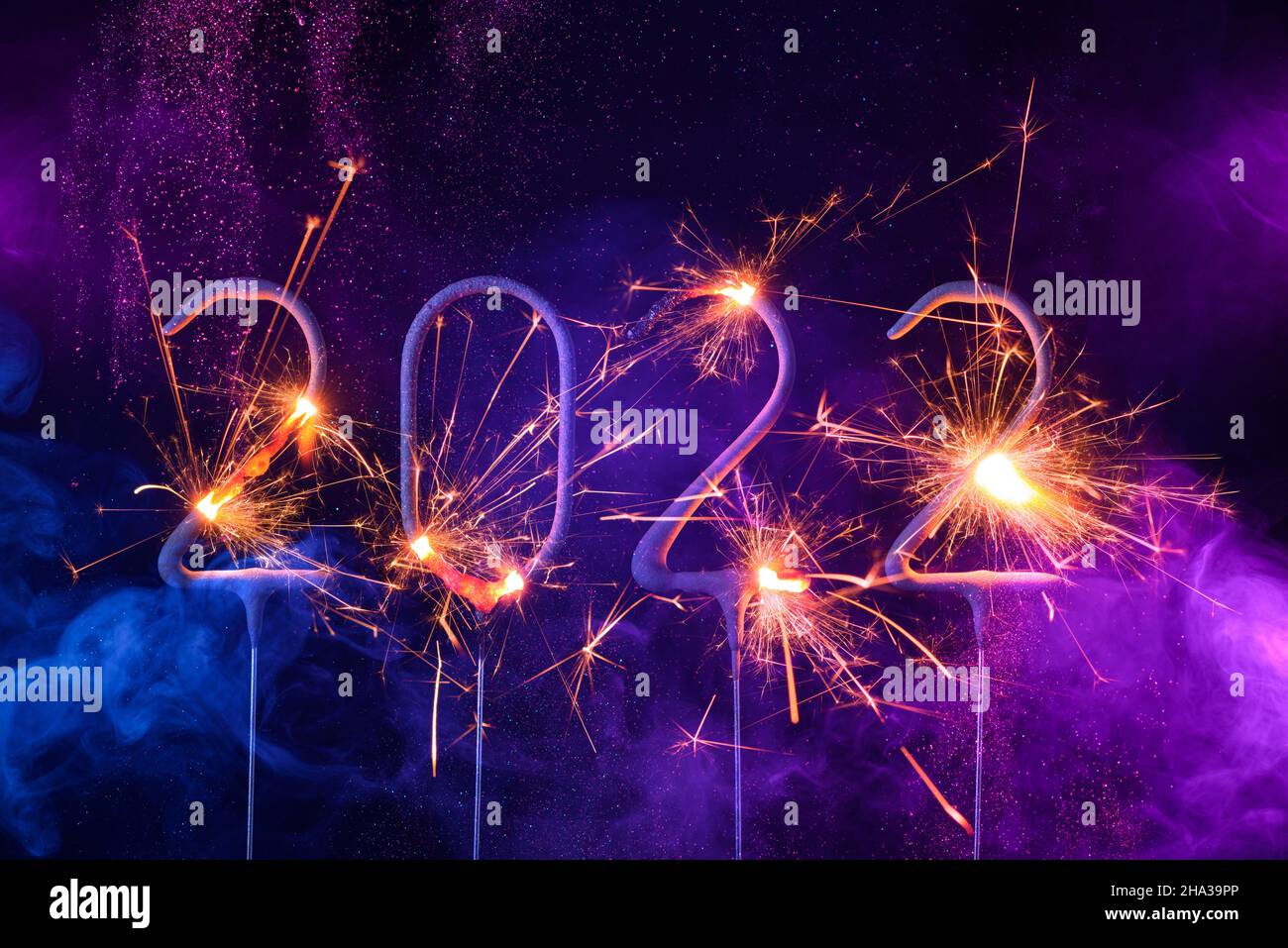 2022 Happy new year card with with sparklers shiny glitter and colorful smoke Stock Photo