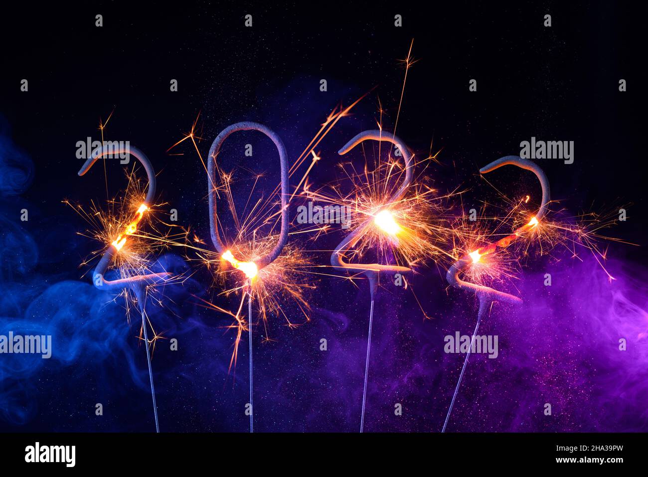 2022 Happy new year greeting card with with sparklers shiny glitter and colorful smoke Stock Photo