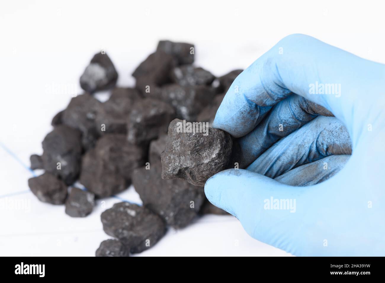 Coal lump in scientist hand. Laboratory coal analysis, fossil fuel research. Stock Photo