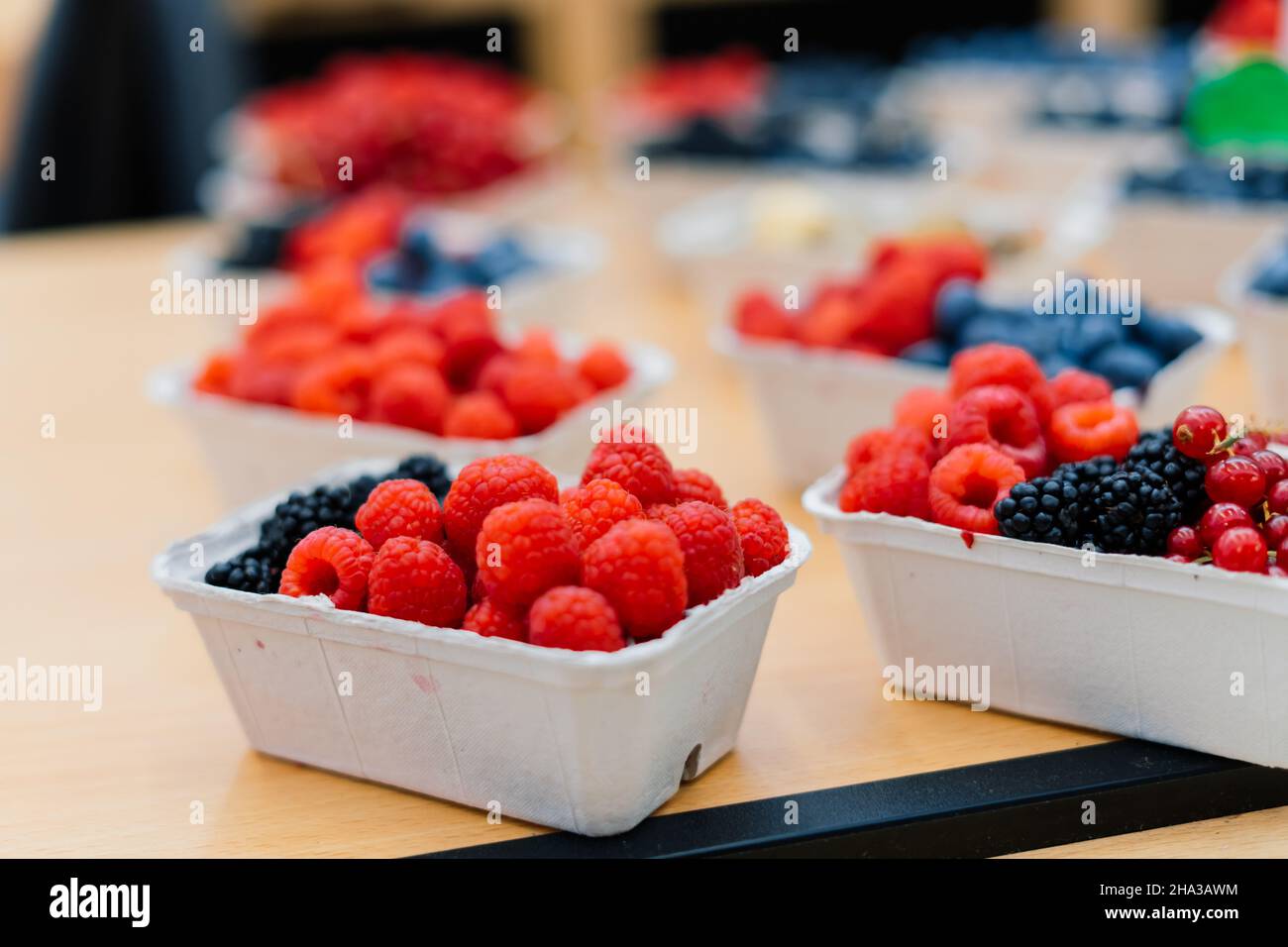 Blueberries and raspberries in box containers at farmers market Stock ...