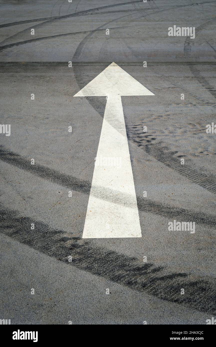 White arrow on an empty car park tarmac Stock Photo