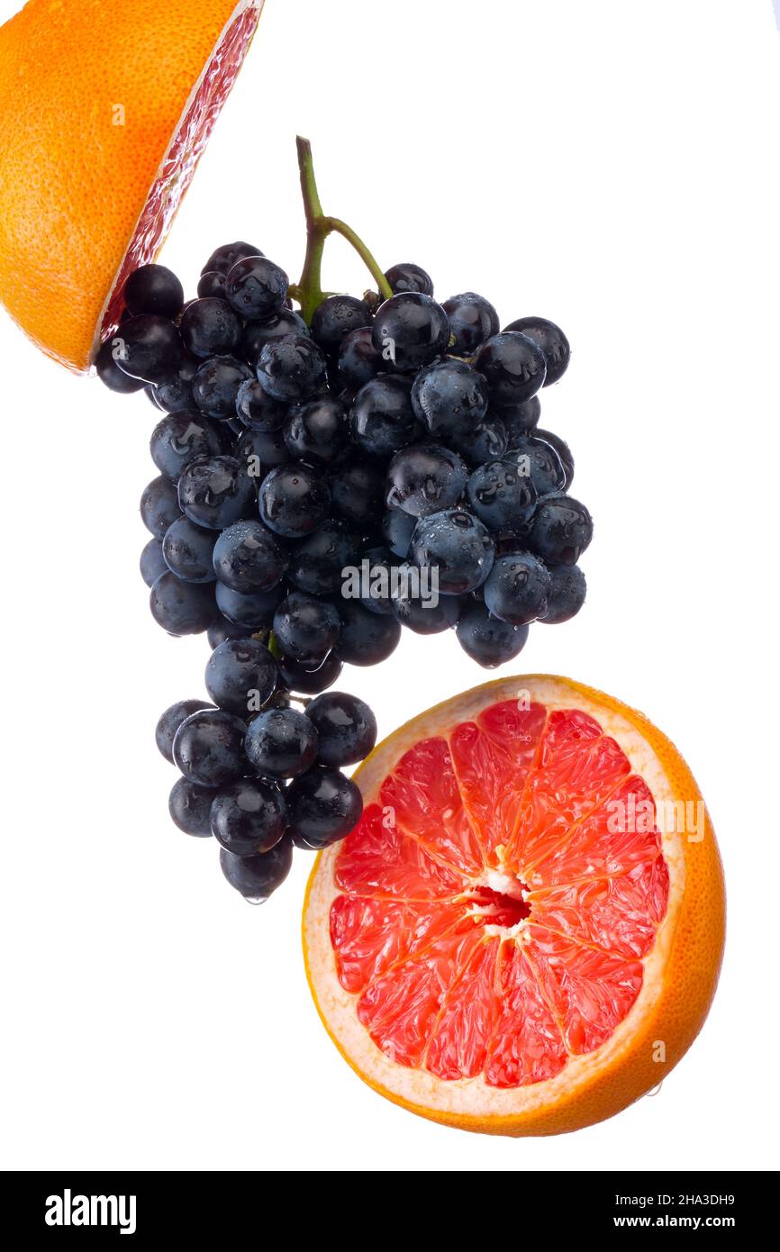 Dark blue grape with red grapefruit isolated on white background Stock Photo
