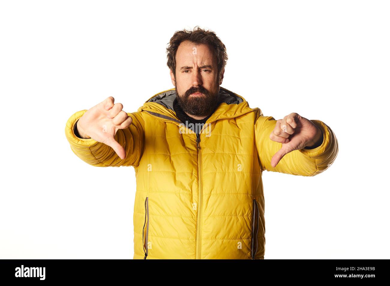 bearded man looking sad, disappointed or angry, showing thumbs down in disagreement, feeling frustrated. Stock Photo