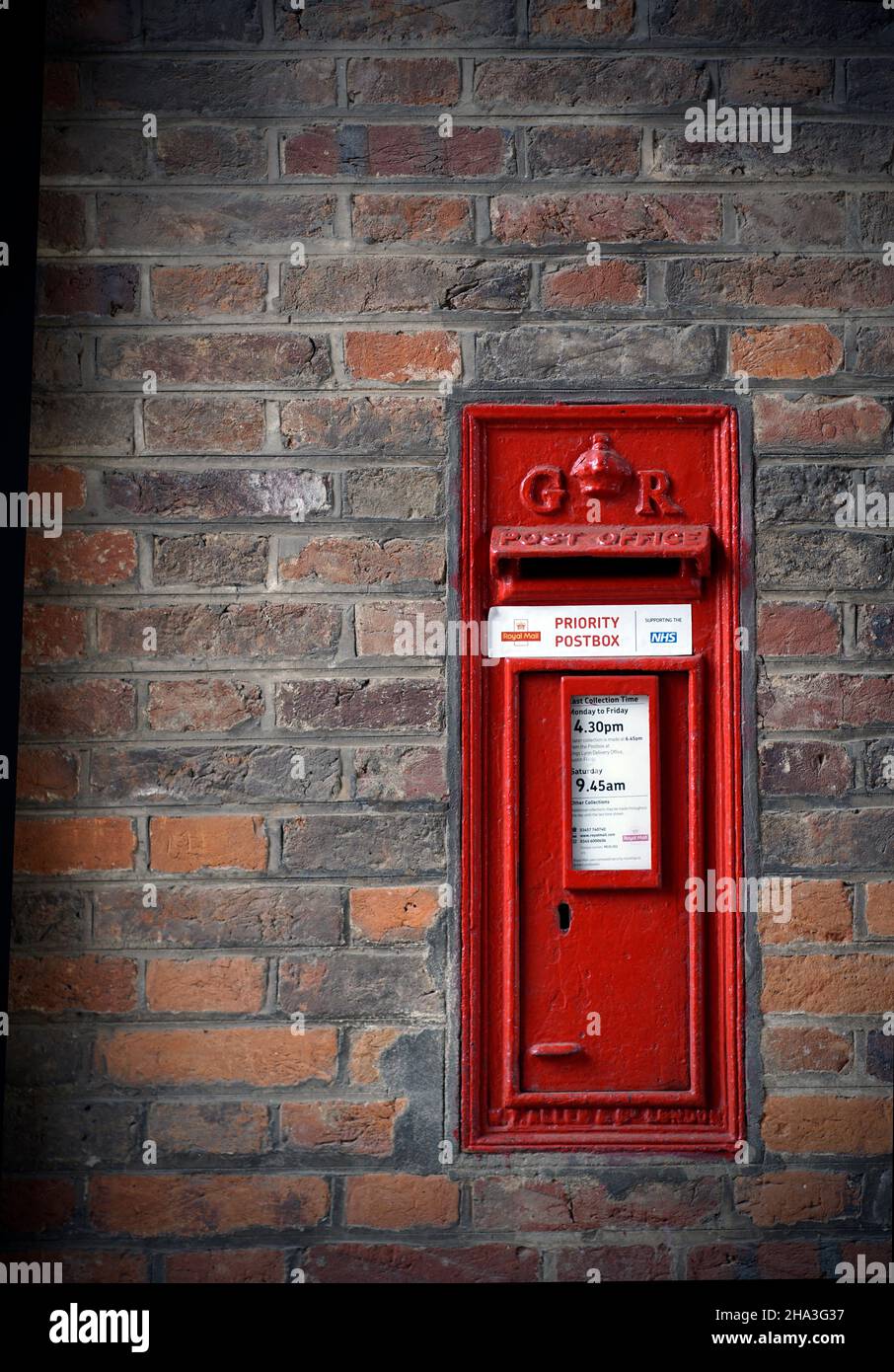 old fashioned red posst office letter box inset in brick wall Stock Photo