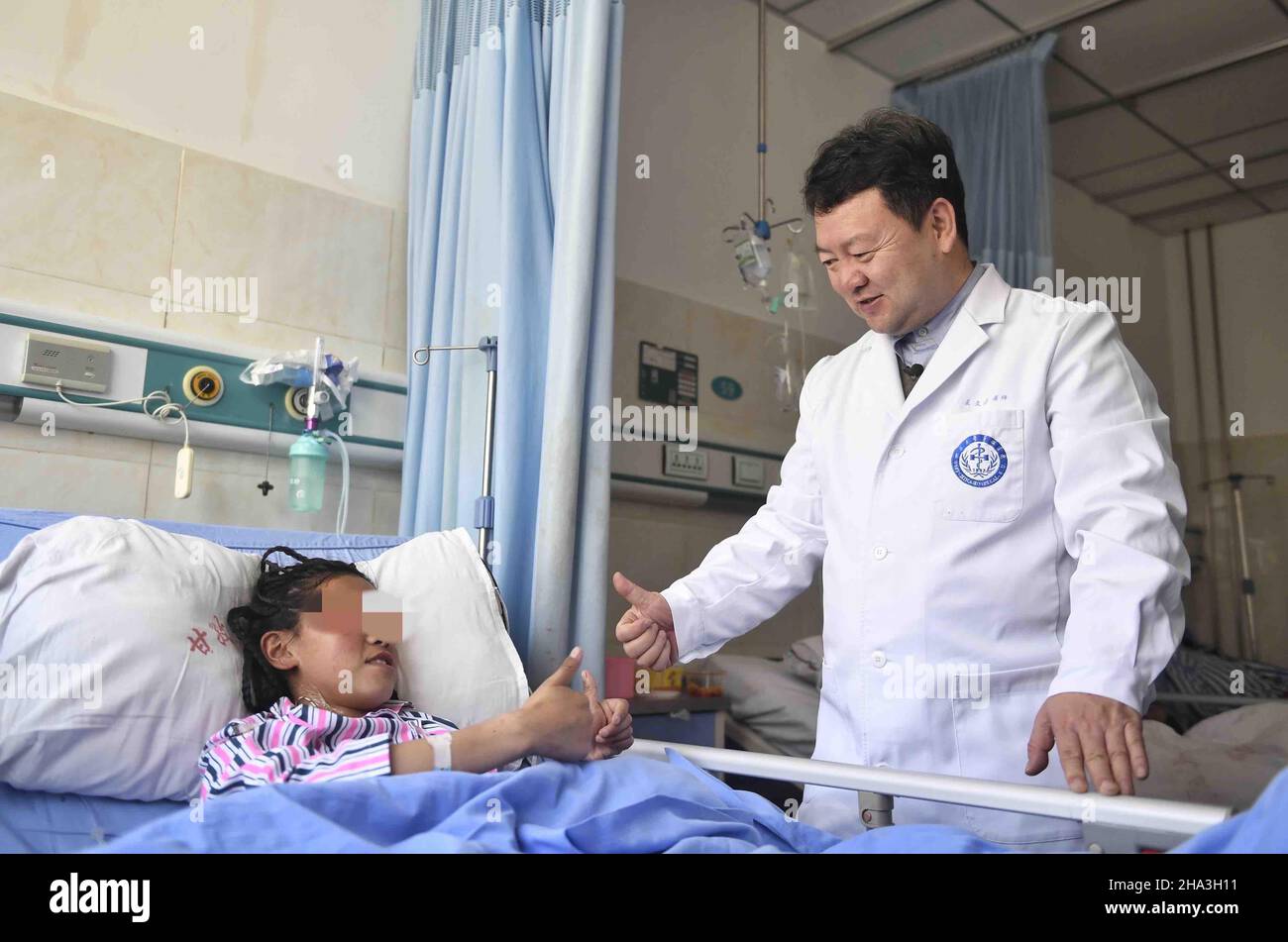 (211210) -- CHENGDU, Dec. 10, 2021 (Xinhua) -- Wang Wentao (R) gives a thumb up to a hydatid disease patient to show encouragement at a hospital in Tibetan Autonomous Prefecture of Garze, southwest China's Sichuan Province, Jan. 16, 2020. Wang Wentao, deputy director of the liver surgery department at West China Hospital of Sichuan University, started his work on the prevention and control of hydatid disease in Tibetan Autonomous Prefecture of Garze in 2006 when he learned that some local people suffer from hydatid disease during one of his free clinic tours there. Hydatid disease, or echin Stock Photo
