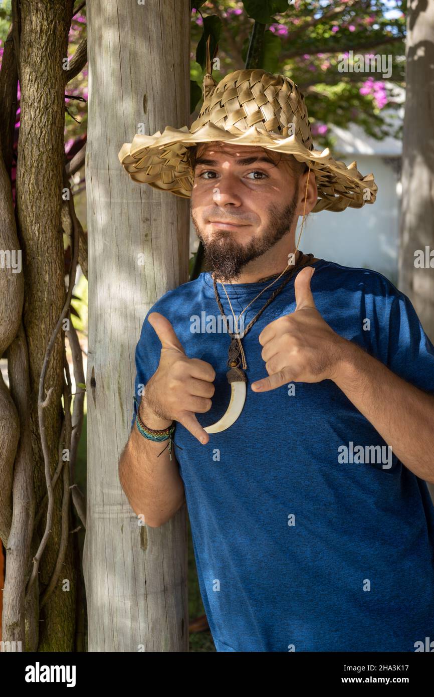 Young adult Caucasian man and hippie gardener look among the plants. Man enjoying his work. Stock Photo