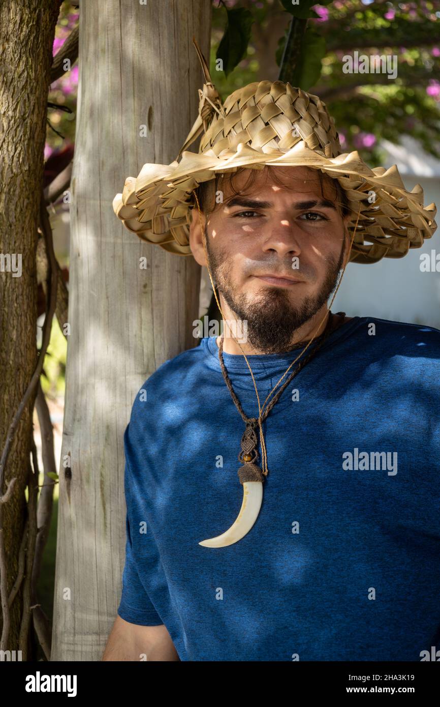 Young adult Caucasian man and hippie gardener appearance with serious look in the park. Free space to write. Stock Photo