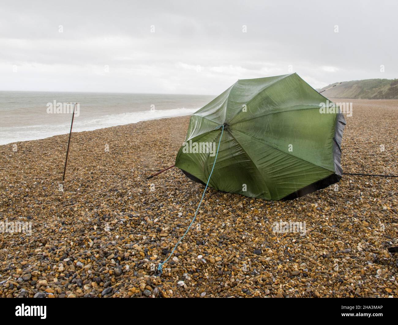 fishing umbrella and empty rod rest  onstony  wet beach dunwich suffolk england Stock Photo