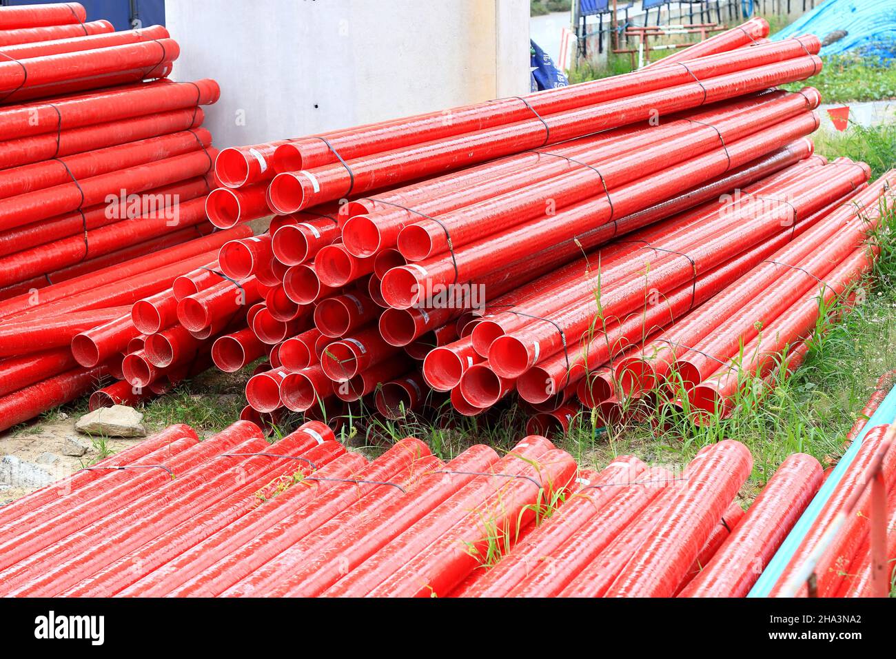 Red Fiberglass pipes at construction site, Corrosion resistant fiberglass composite pipe used in industrial applications. Stock Photo