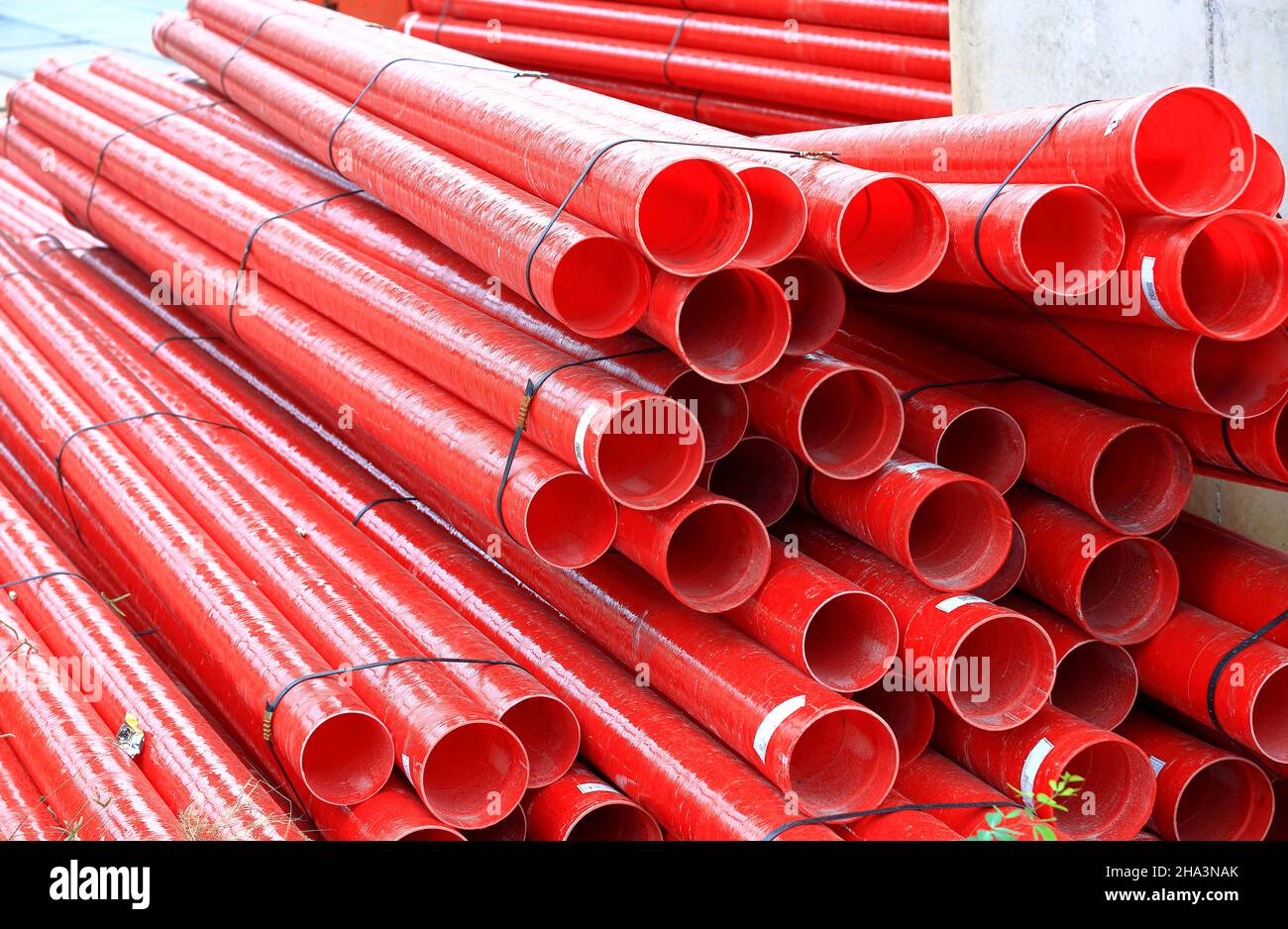 Red Fiberglass pipes at construction site, Corrosion resistant fiberglass composite pipe used in industrial applications. Stock Photo