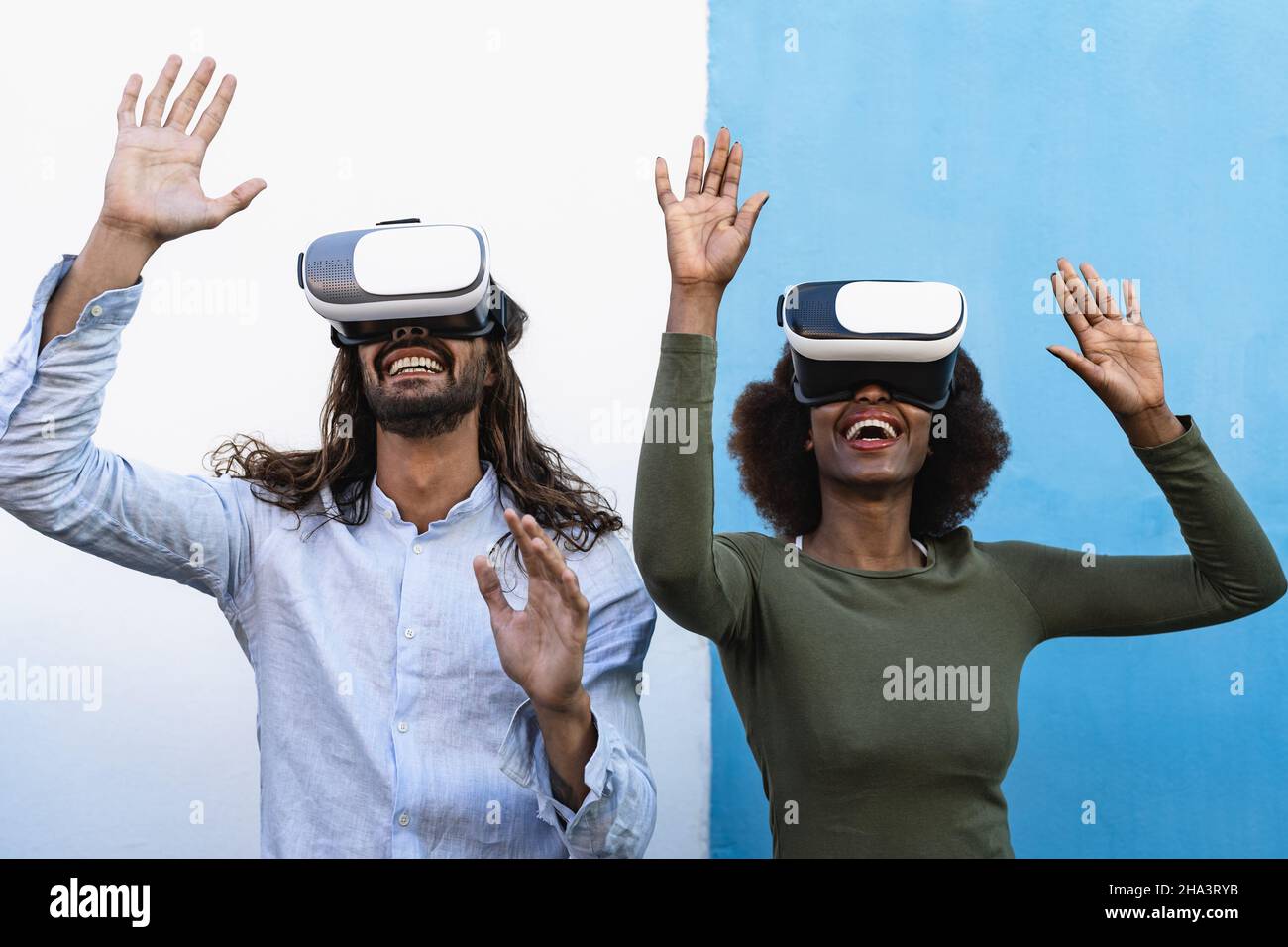 Happy friends having fun playing with innovated virtual reality glasses - Tech gaming entertainment and metaverse concept Stock Photo