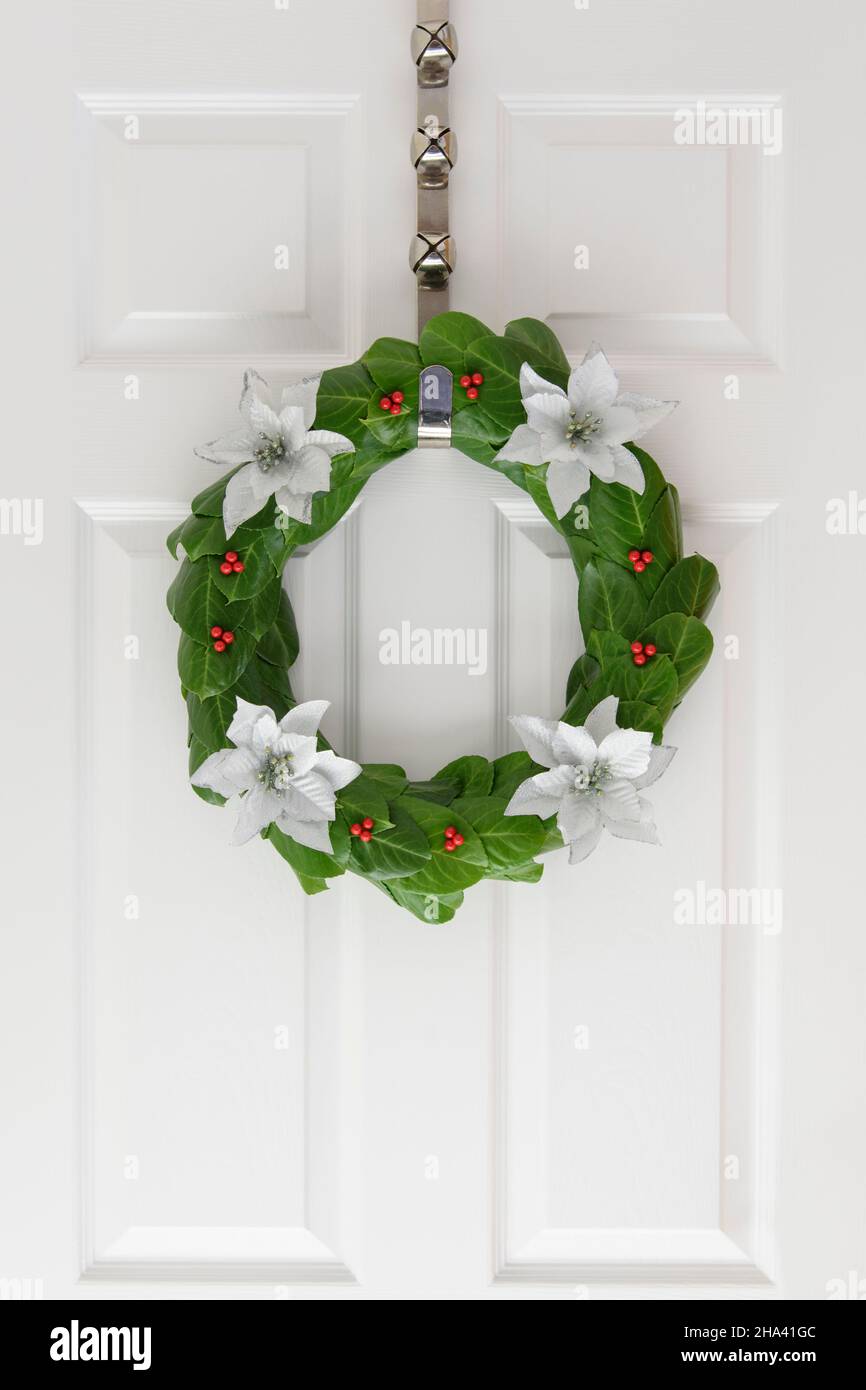 Laurel Christmas door wreath with red berries and white poinsettia ...