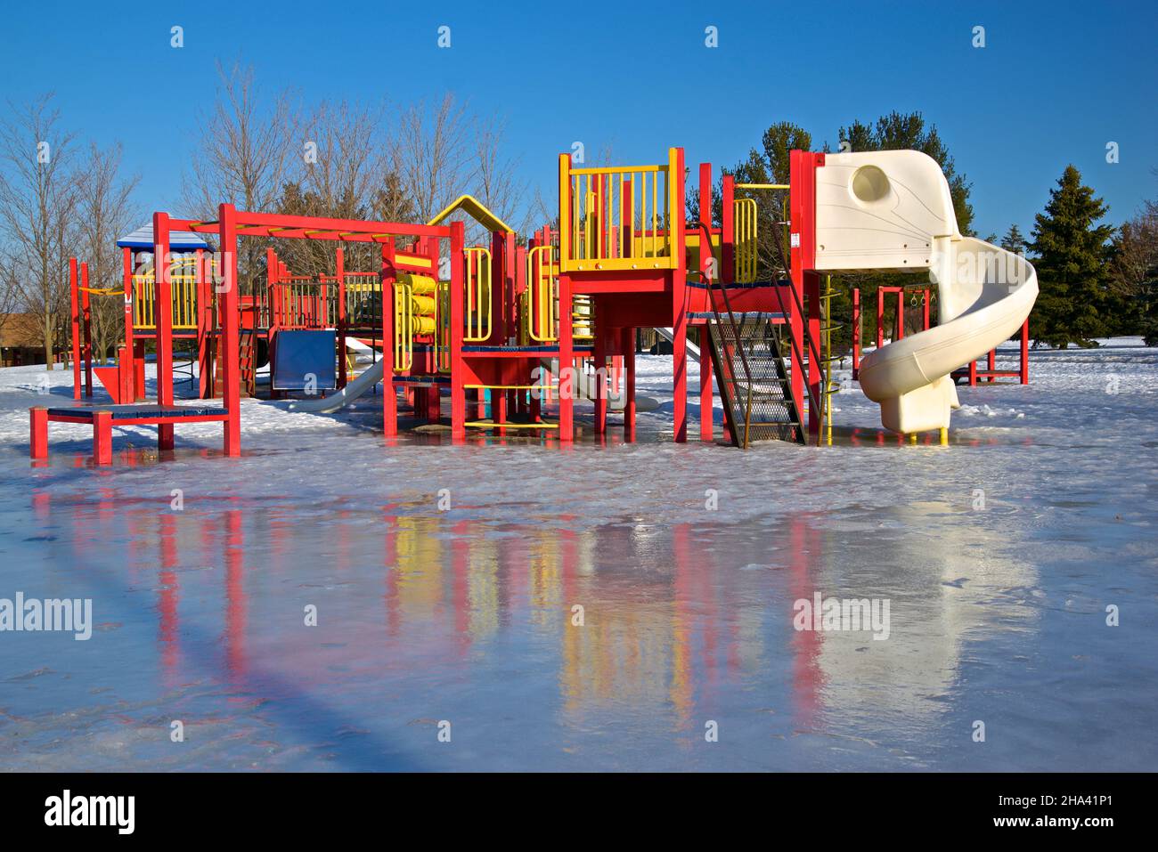 Reflection of the slide in the playground at the public park in winter Stock Photo