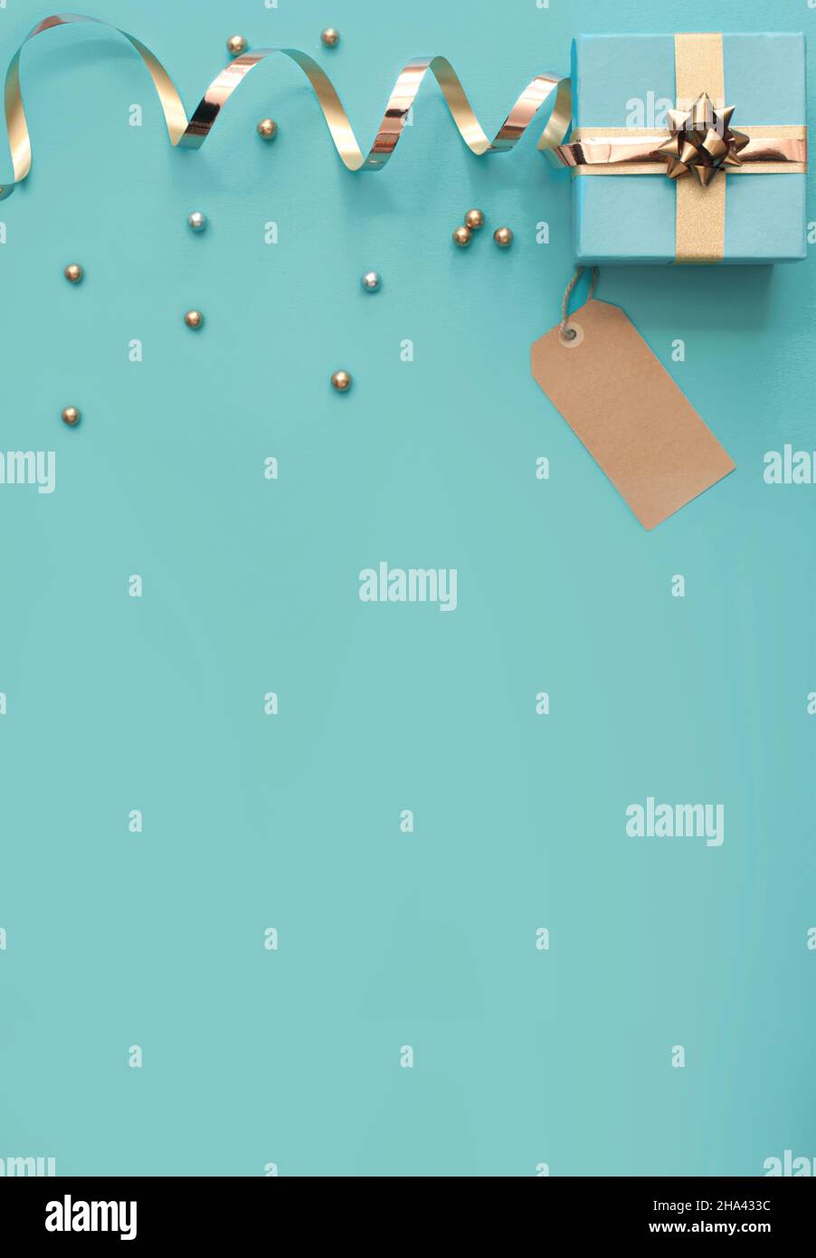 Seasonal gift box wrapped with with gold ribbon bow and greeting card