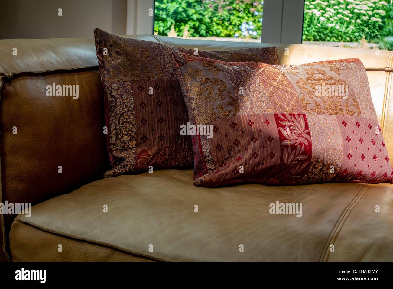 cushions on brown leather sofa Stock Photo Alamy