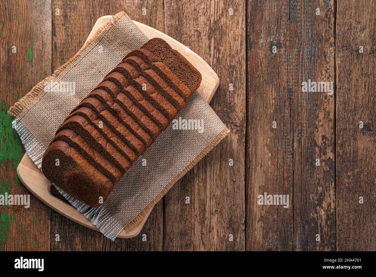 Rye bread cut into pieces on a wooden background. Top view, copy space. Stock Photo