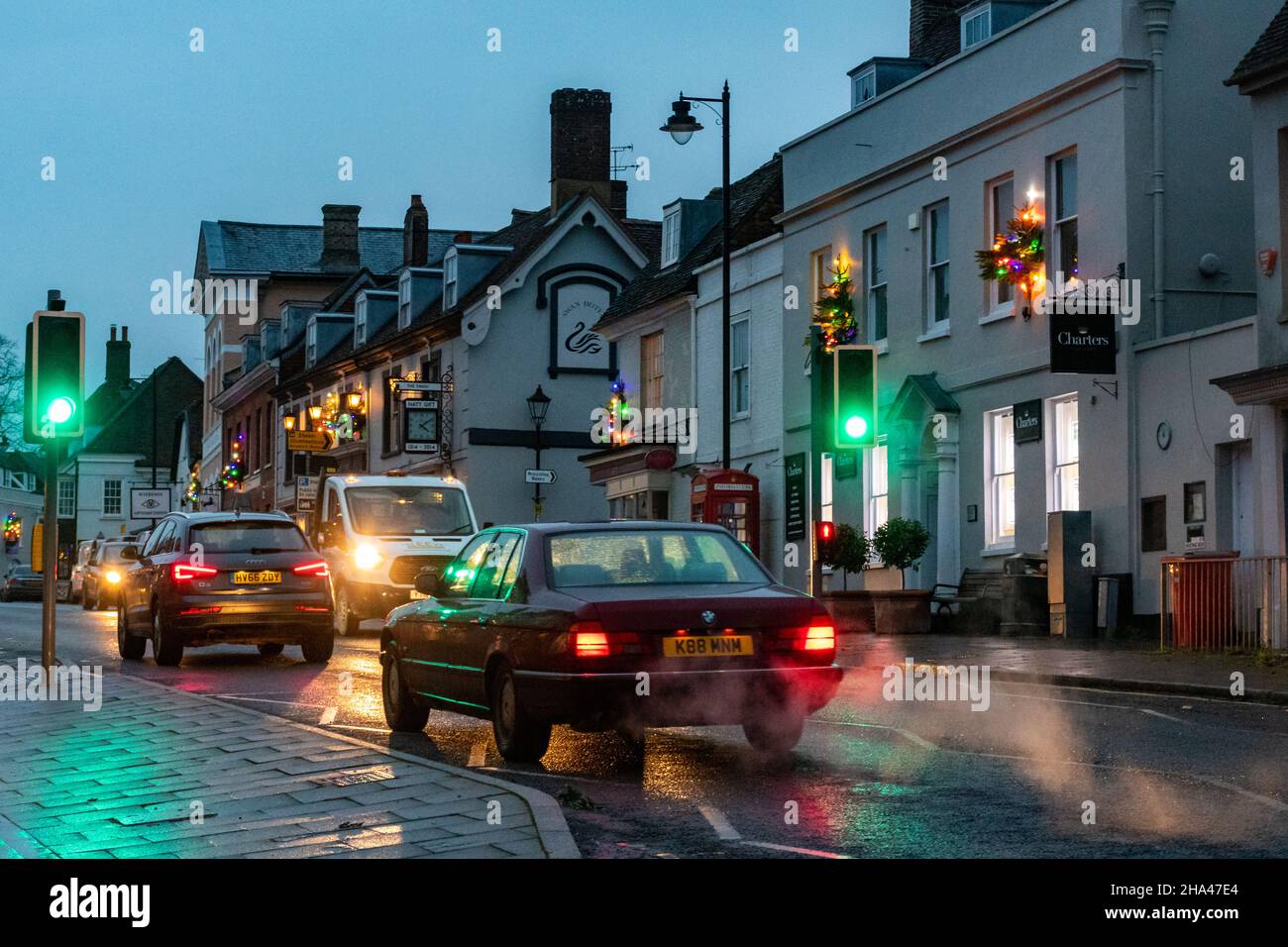 Car exhaust fumes from busy road traffic causing air pollution in a town centre, England, UK, seen at dusk during December 2021. Stock Photo