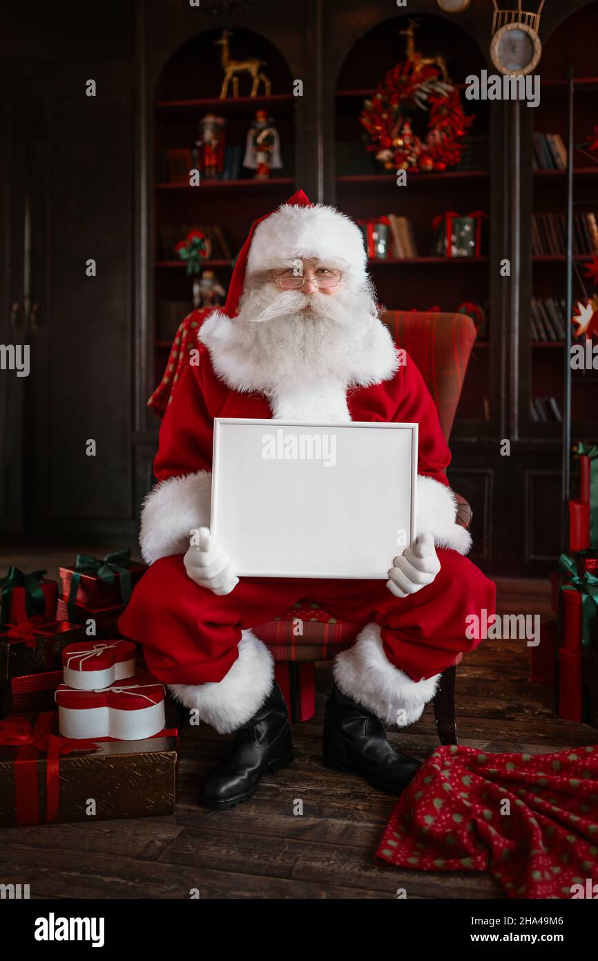 Santa Claus holding white frame in his hands Stock Photo