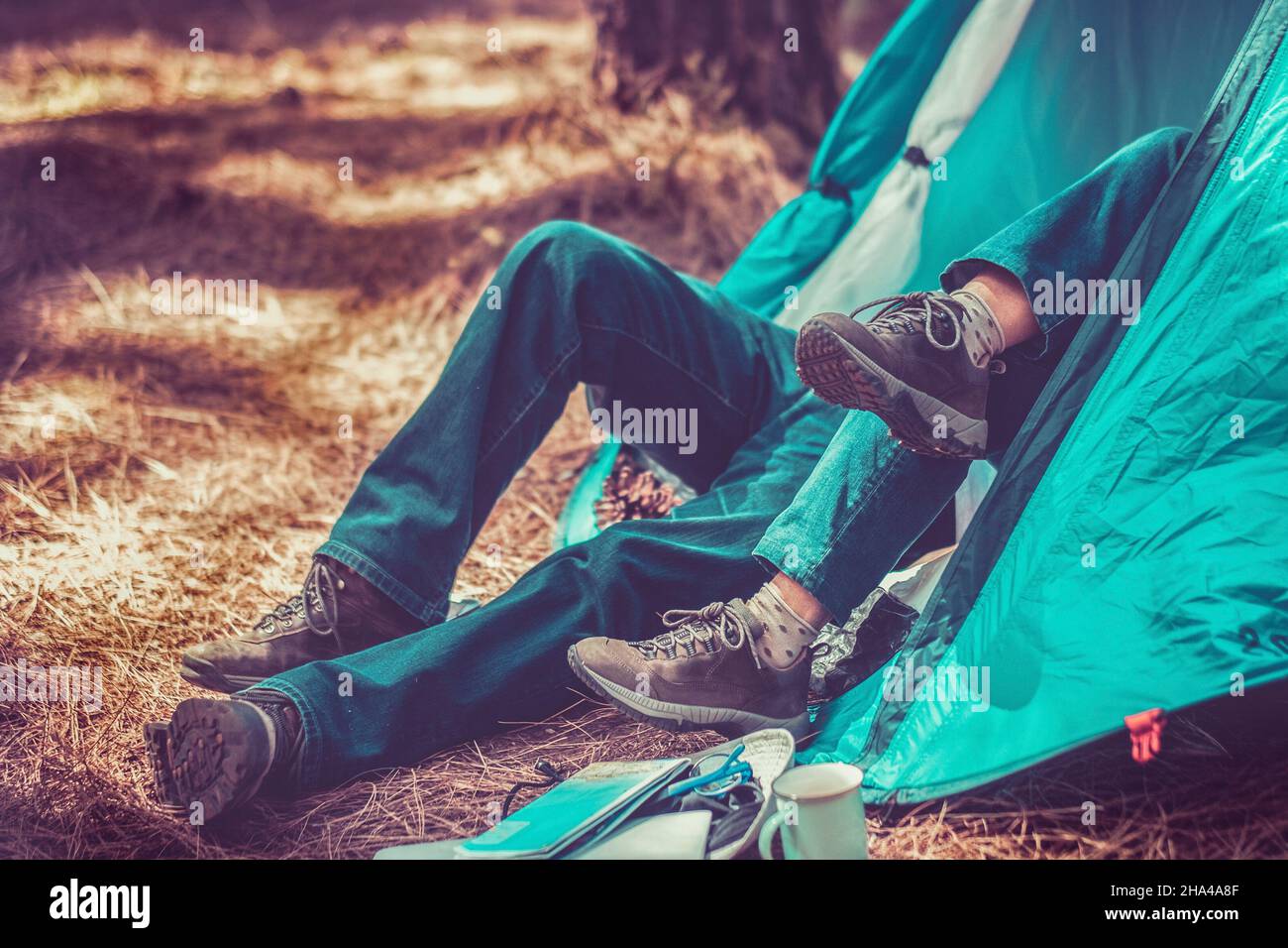 couple inside a tent in outdoor free woods camping activity - mountain trekking shoes and alternative adventure forest lifestyle people - free tourism vacation lifestyle people enjoying environment and nature Stock Photo
