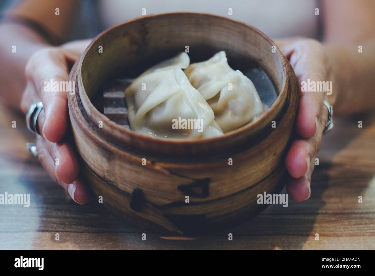 hands holding bowl with fresh chinese ravioli Stock Photo
