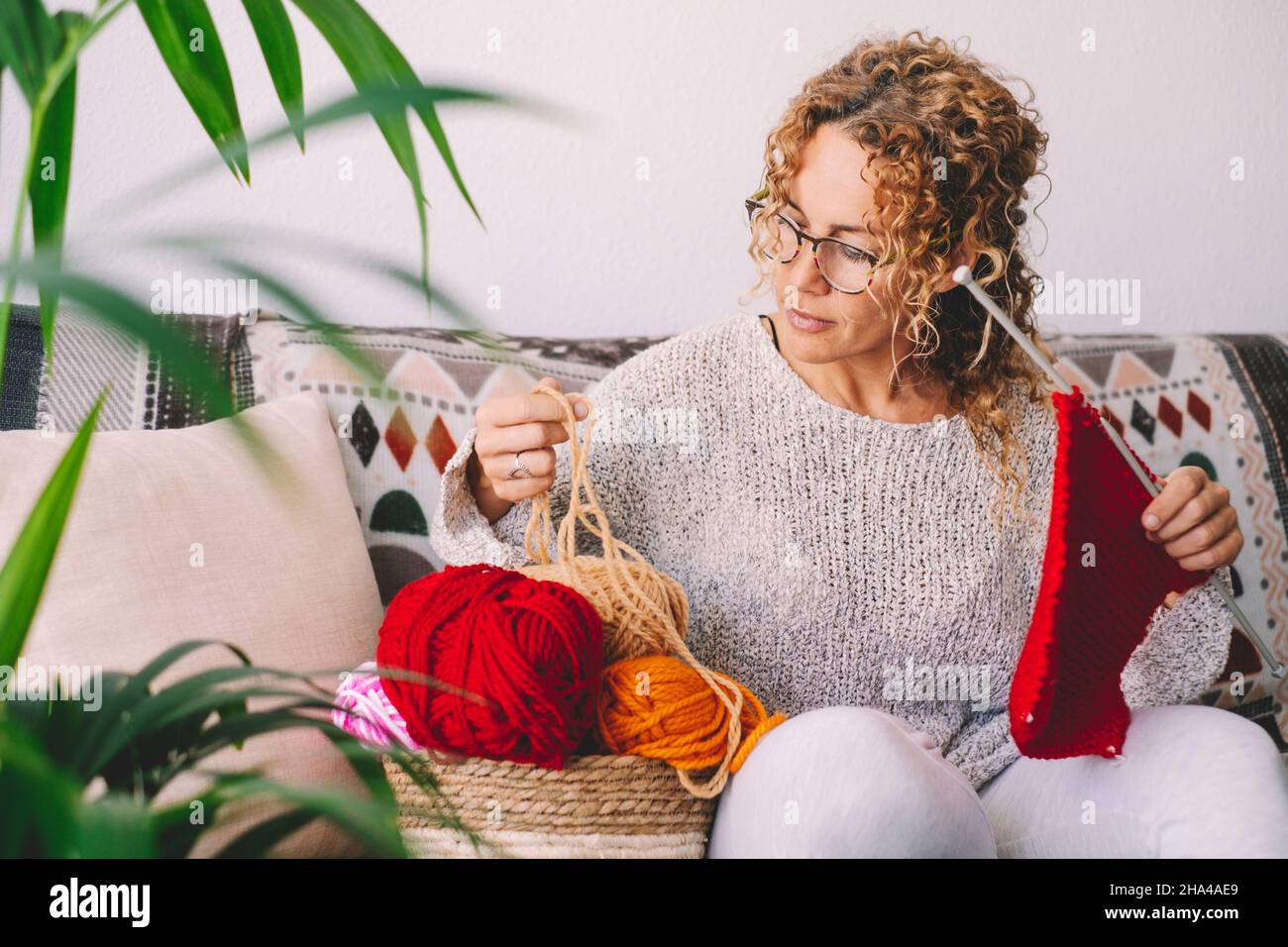 adult attractive woman at home in knitting work activity using colorful