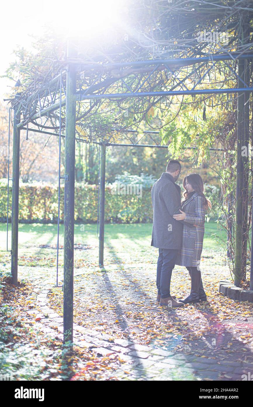 Embracing young european man and woman with dark hair in park in ...
