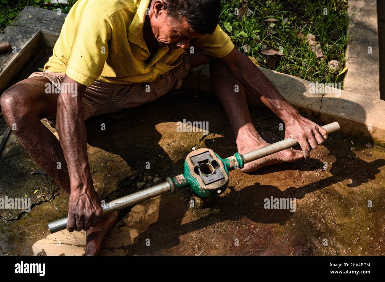 December 8, 2021, Tehatta, West Bengal, India: A recent report published by the Reserve Bank of India (RBI) shows that the daily wage of rural workers in West Bengal is way below the national average. A worker is repairing a tubewell (hand pump) at Tehatta, West Bengal. (Credit Image: © Soumyabrata Roy/Pacific Press via ZUMA Press Wire) Stock Photo