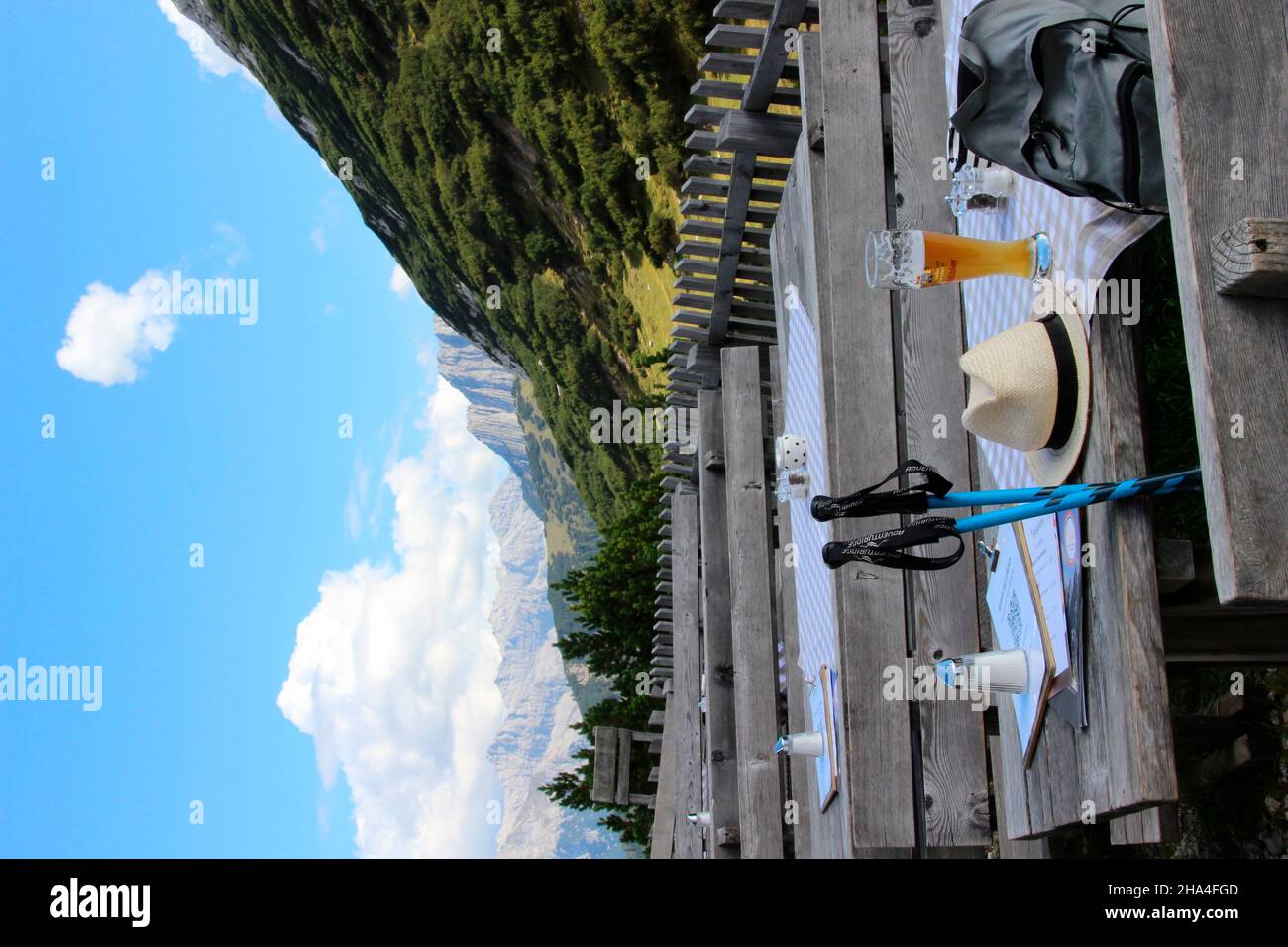 hike with a break on the terrace of the solsteinhaus (1806m) of the innsbruck austrian alpine club section,table with sun hat,wheat beer,hiking sticks,austria,tyrol,zirl Stock Photo