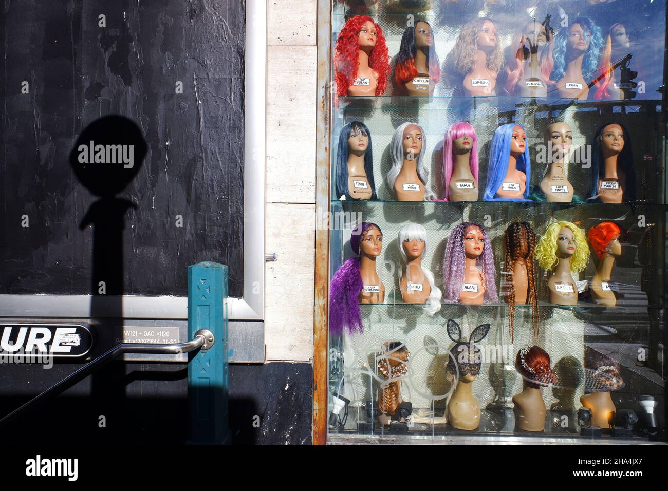 Colorful wigs on mannequin's heads display in a shop window in Garment
