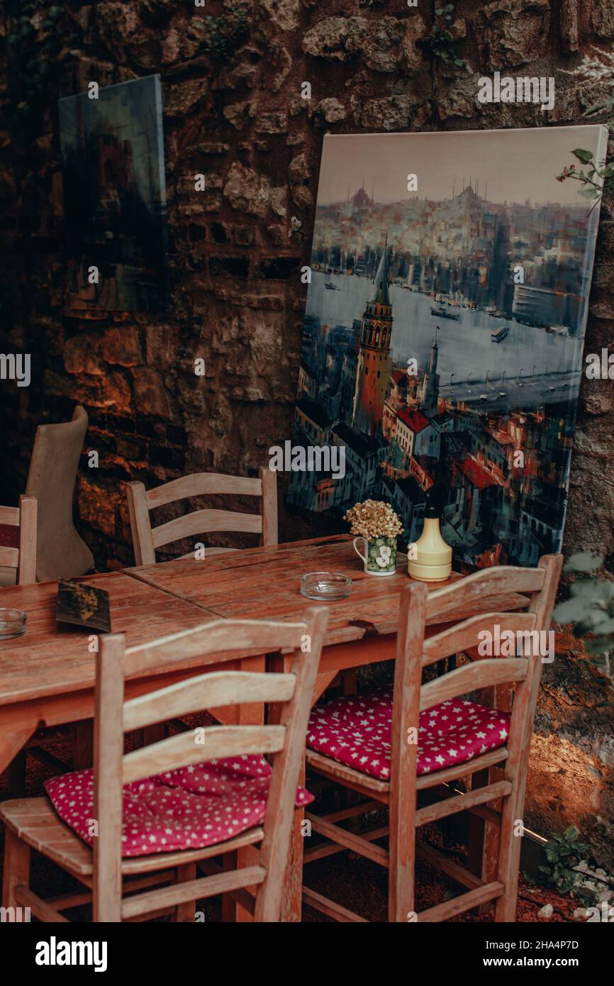 Wooden table, chairs in the interior of a vintage Turkish cafe with a picture of Istanbul Stock Photo