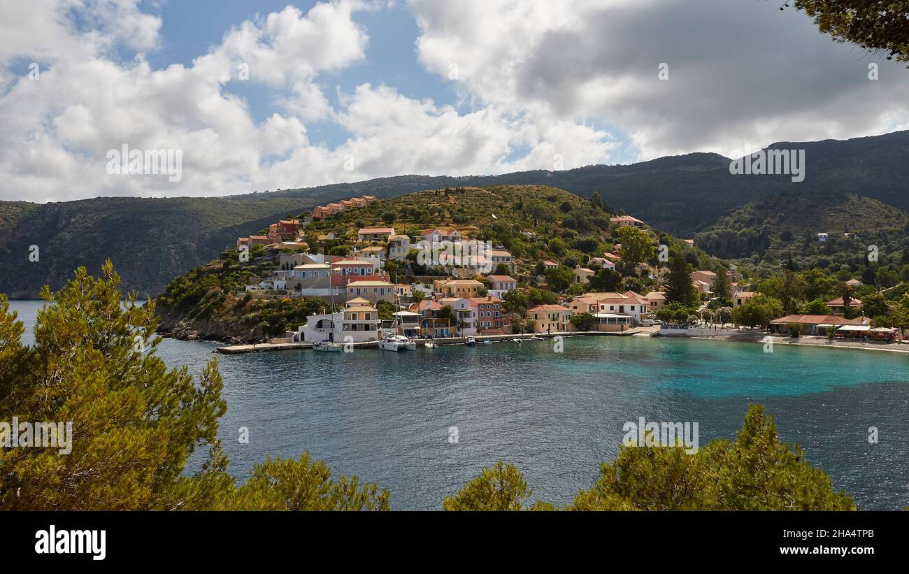 greece,greek islands,ionian islands,kefalonia,assos,place on the west coast,venetian fortress,way to the fortress,view over to the place assos,sky blue with clouds gray and white,sea blue and turquoise,trees in the foreground Stock Photo
