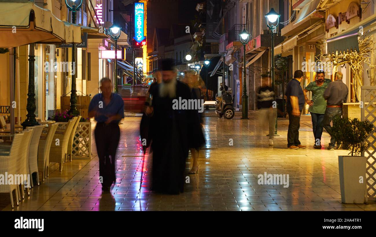 greece,greek islands,ionian islands,kefalonia,argostoli,capital of kefalonia,pedestrian zone,night shot,pavement shines from the rain,blurred people,pope in the foreground,light reflections on the ground Stock Photo