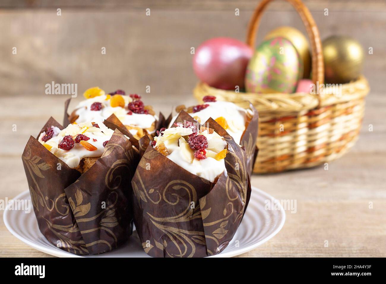 Easter eggs in a basket on a rustic wooden background. Easter background. Happy easter eggs on nest. Multi-colored Easter eggs. Stock Photo