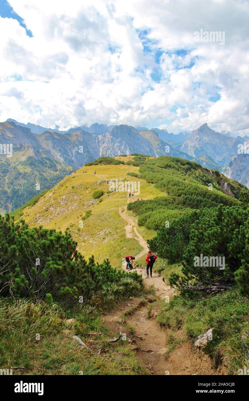 ascent to bärenkopf (1991m),hiking trail,stony,hikers on the last meters to the summit,mountain ridge,cloud formation,blue sky,achensee,tyrol,austria Stock Photo
