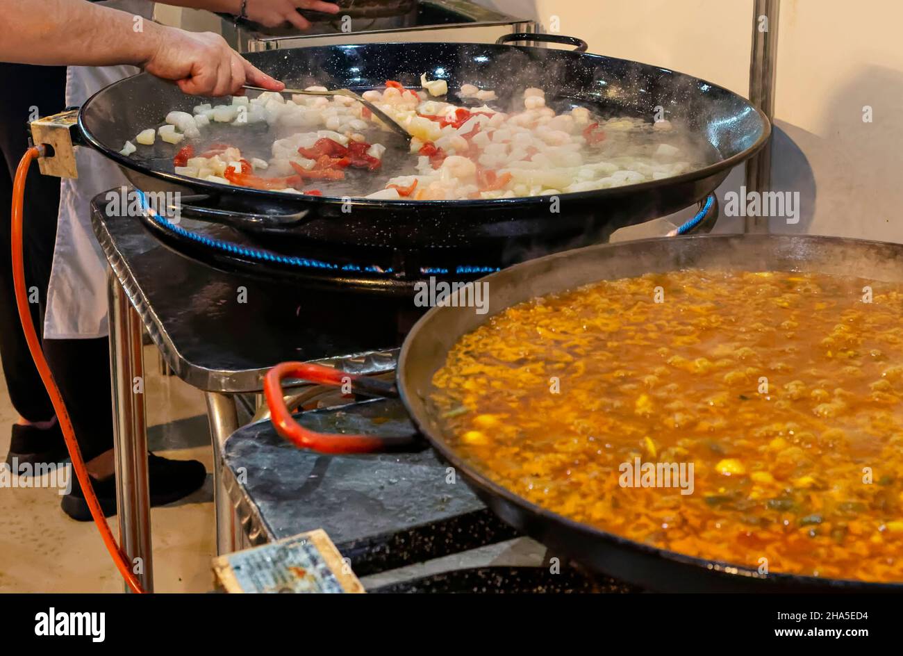 Cooking process of a traditional Valencian paella in a paella pan, with
