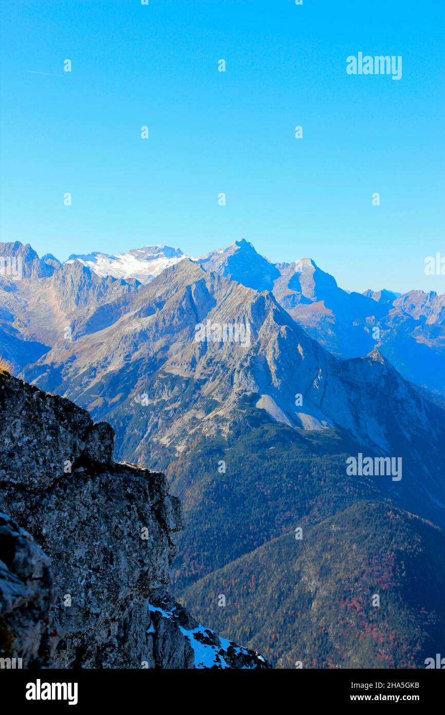 view from karwendel,karwendelbahn mountain station to the wetterstein mountains,with wetterstein,wettersteinspitzen,alpspitze,zugspitze,wetterstein massif in the foreground the grünkopf above mittenwald,in front of blue sky,germany,bavaria,upper bavaria, Stock Photo
