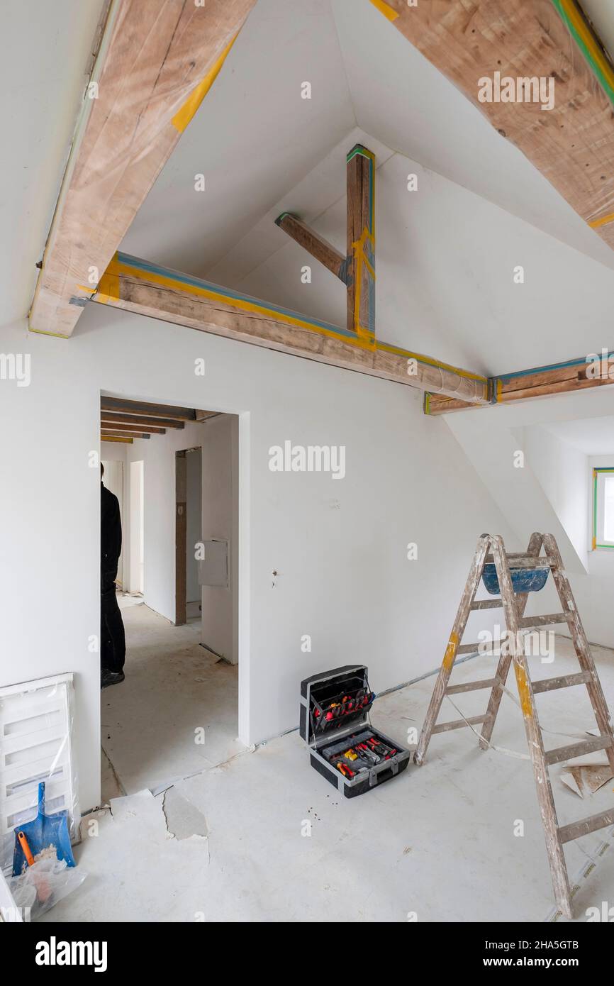 construction site,refurbishment and renovation of an apartment,empty room in the attic with a wooden beam ceiling Stock Photo