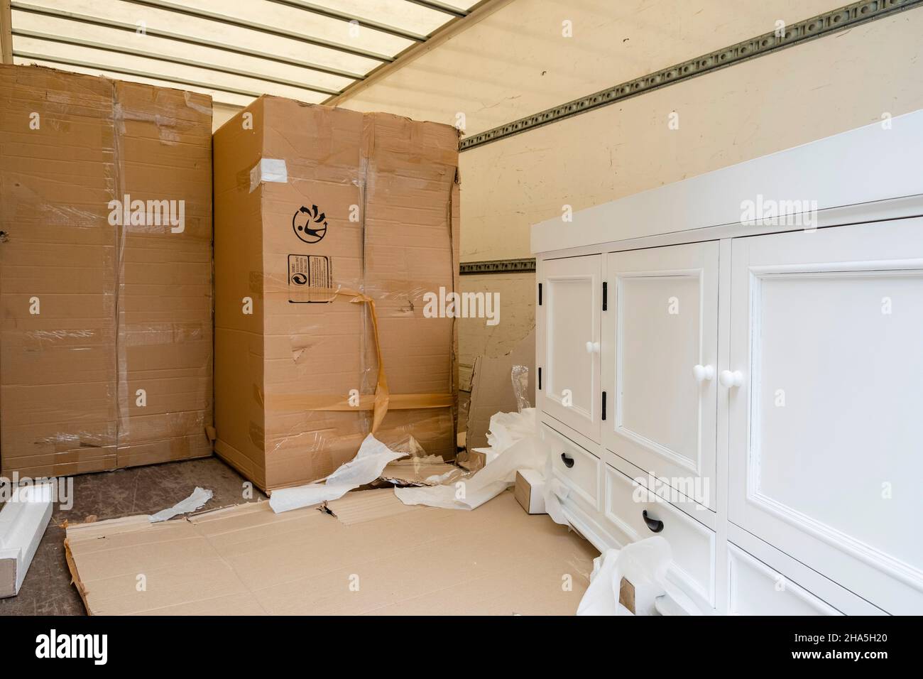 construction site,refurbishment and renovation of an apartment,packed furniture and moving boxes on the loading area of a truck Stock Photo