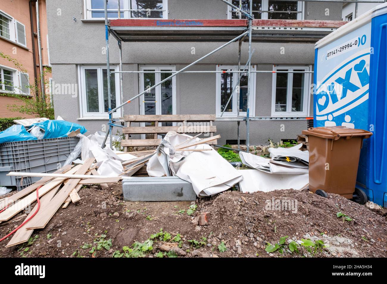 construction site,refurbishment and renovation of an apartment,waste and material leftovers in front of a refurbished house Stock Photo