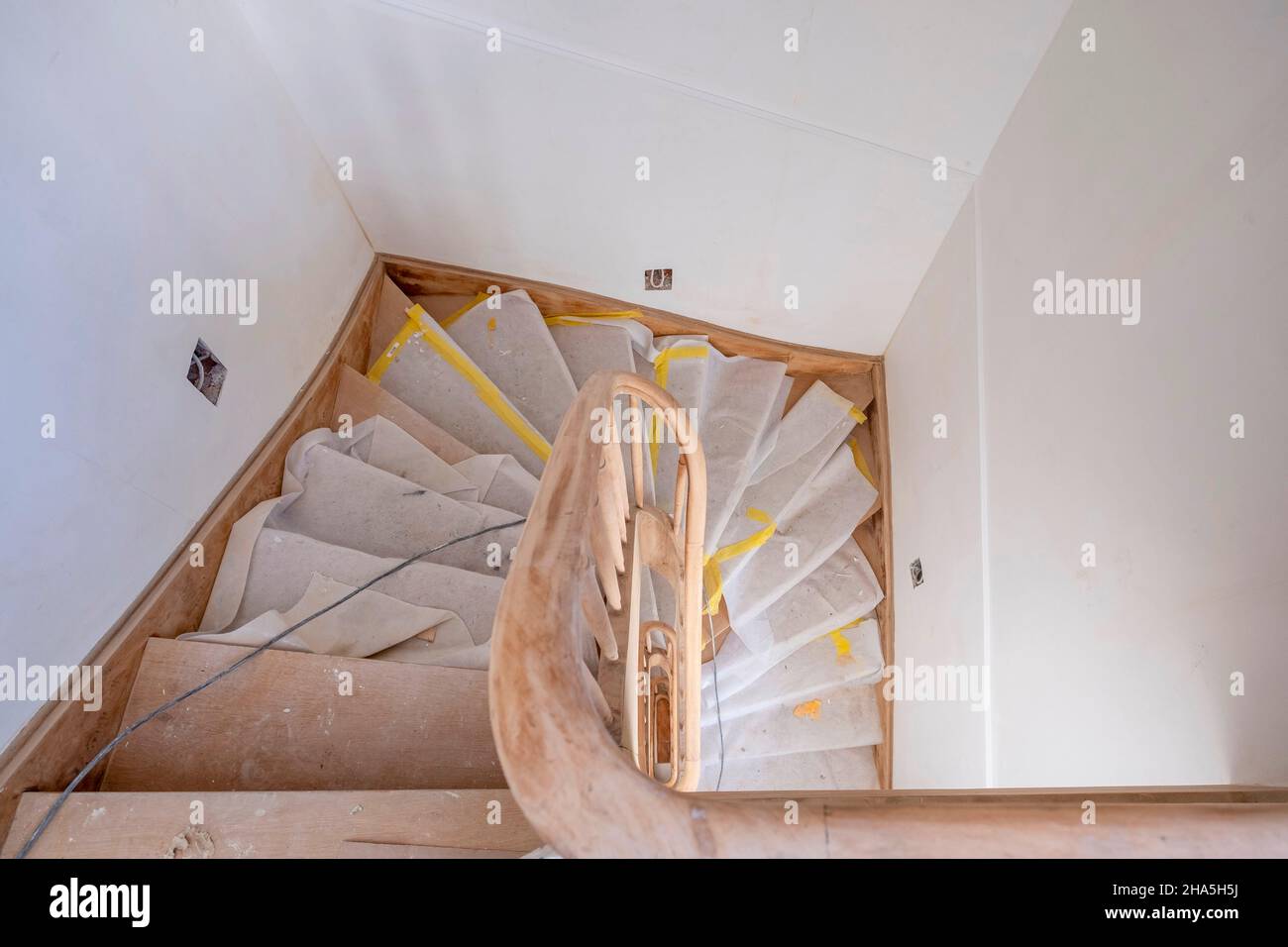 construction site,refurbishment and renovation of an apartment,covered wooden stairs in the stairwell of an old building Stock Photo